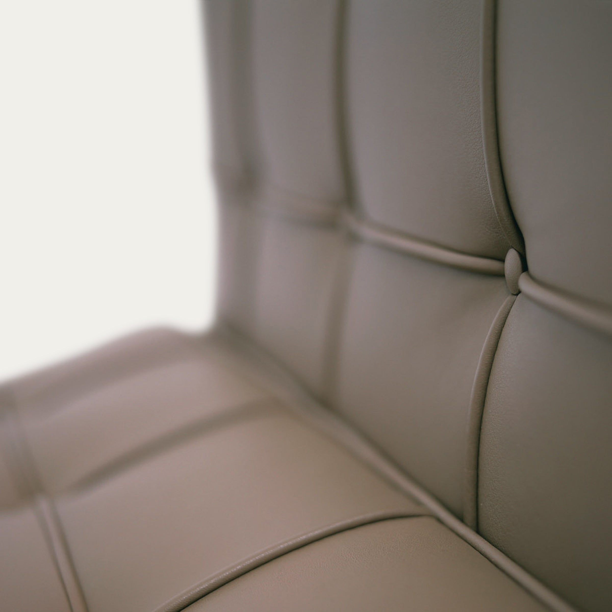 Makroaufnahme der gepolsterten Lederfläche des Barcelona Chairs von Mies van der Rohe mit Knopfsteppung