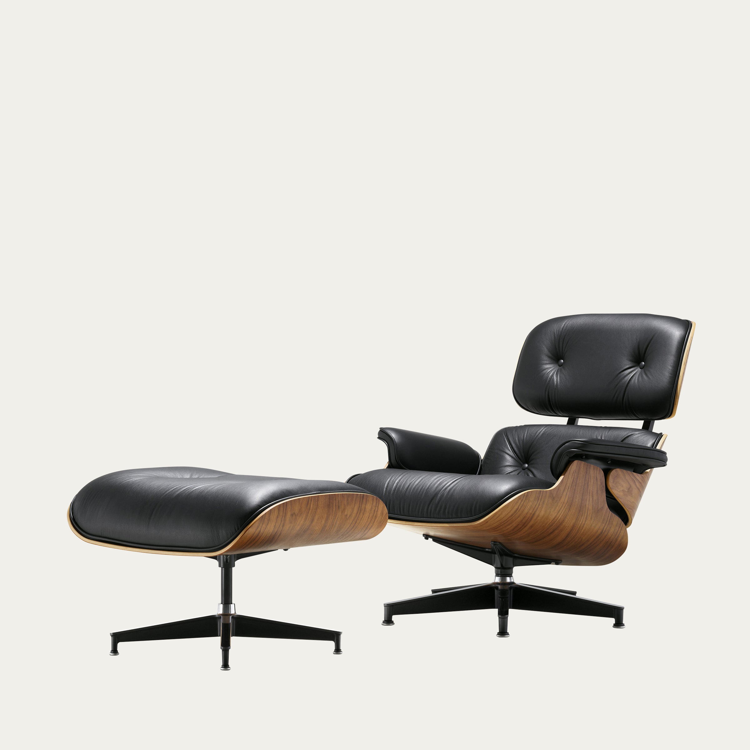 Seitenansicht des Eames Lounge Chair mit Ottoman von Charles & Ray Eames in schwarzem Leder und geölter Nussbaum-Schale