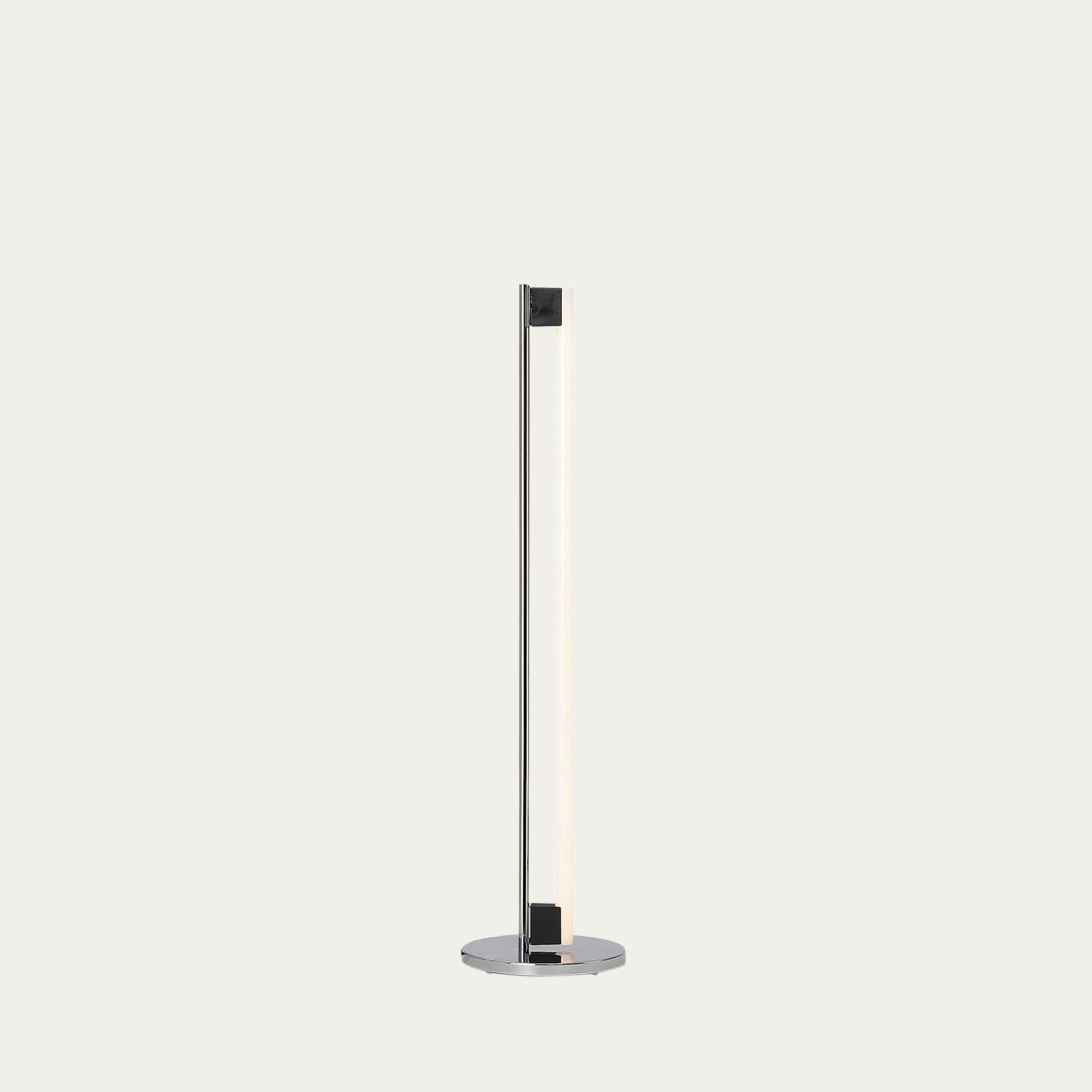 Tube Light Stehleuchte von Eileen Gray 1927 im eingeschalteten Zustand mit warmem Licht und schlankem Stahl- und Glasdesign